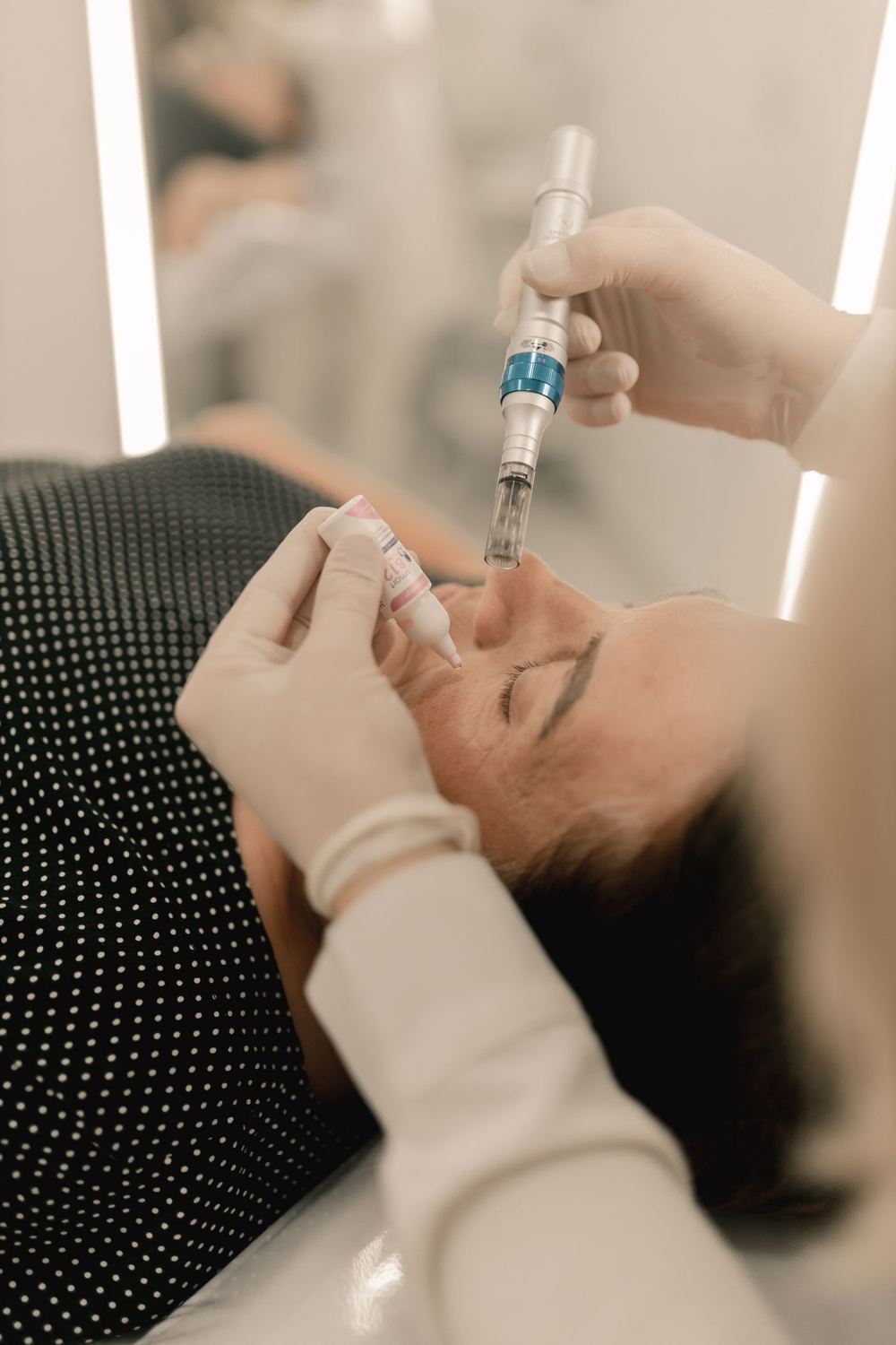 A client receiving a precise aesthetic treatment to the face in a calm, low-lit clinic room