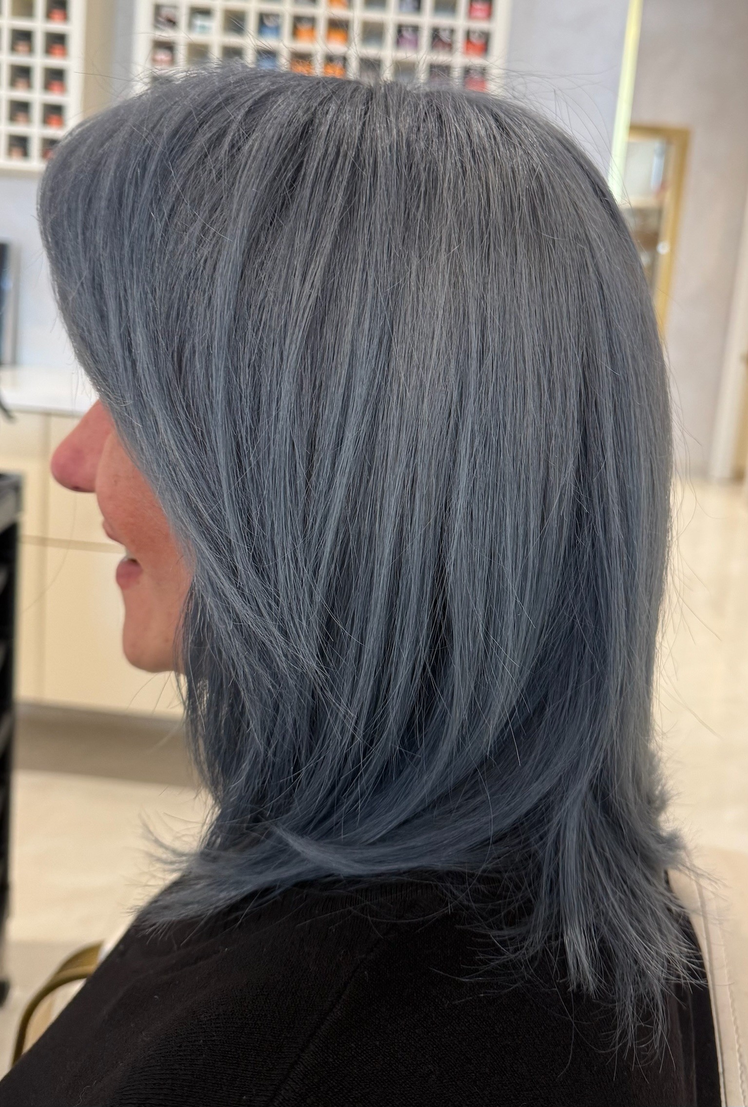 Dimensional balayage highlights on dark hair, styled with loose curls, back view