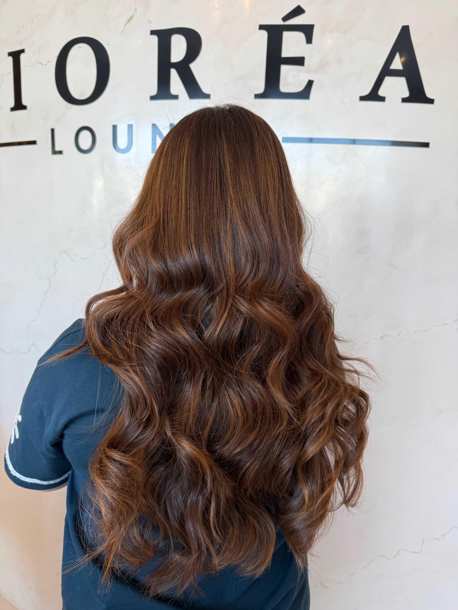 Warm copper-brown hair colour result, long wavy hair, at Lioréa Lounge